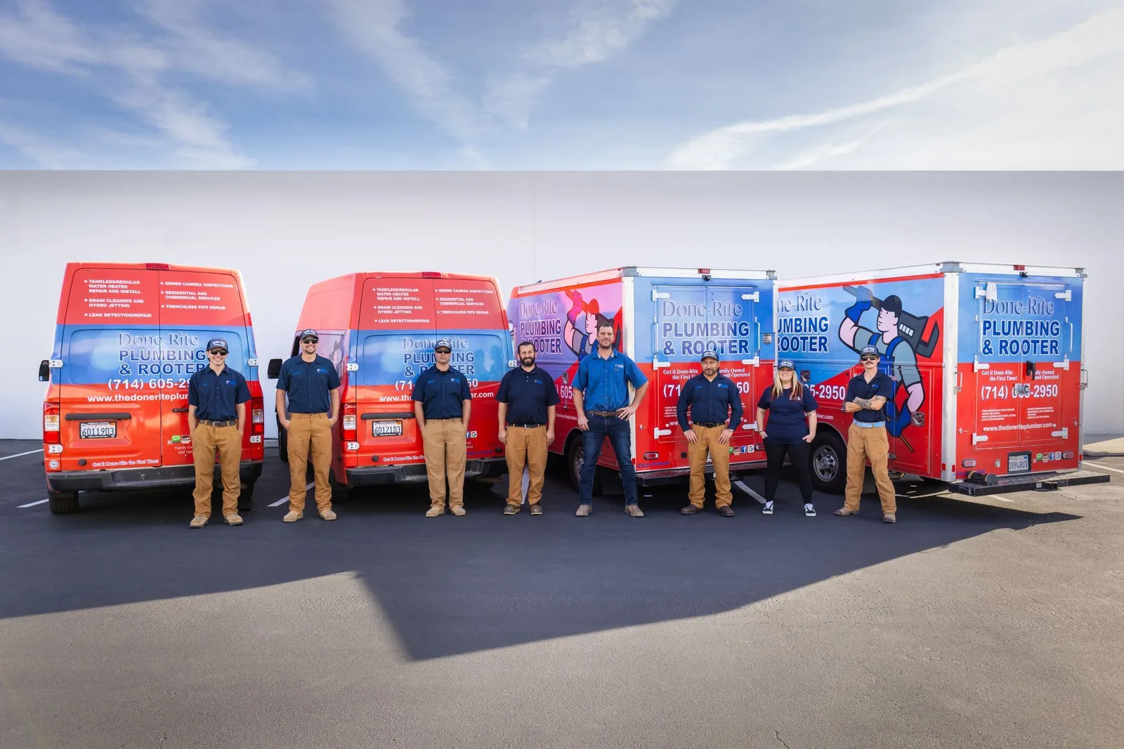 Done-Rite Plumbing & Rooter crew standing in front of their red and blue service vans
